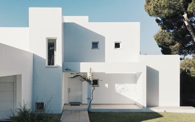 Exterior of two level white Art Deco style house in garden